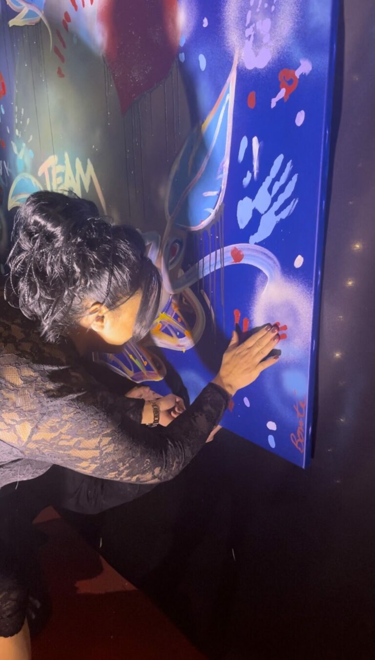 Une invitée pose la main sur la toile pendant la soirée GSF Mercure