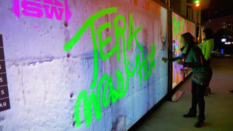 Graffiti digital projeté en grand format sur un mur pendant un événement