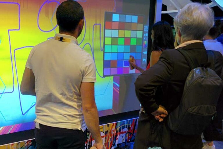 Participants qui choisissent leurs couleurs sur la palette du mur de graffiti digital