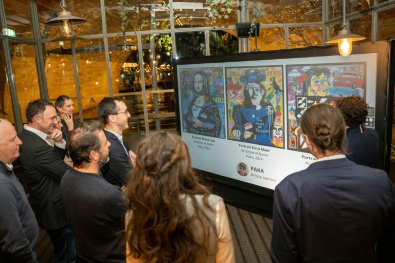 Invités réunis devant leurs créations sur le mur de graffiti digital lors d'une soirée d'entreprise