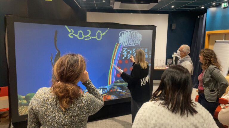 Visiteurs qui dessinent ensemble sur le mur de graffiti digital
